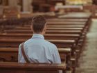 Man sitting along in pew, back to viewer. by the Forward
			