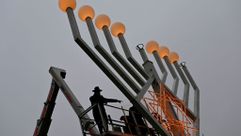 Rabbis inspecting a giant public menorah in Berlin. by the Forward
			
