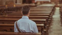 Man sitting along in pew, back to viewer. by the Forward
			