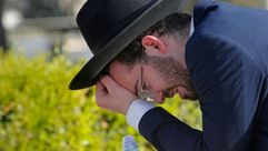 An man mourns at Segula cemetery during the funeral of a victim of the stampede at a Lag B'Omer event at Mount Meron in Israel. by the Forward
			