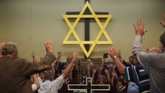 Hands raised in prayer at the Binghamtown Baptist Church in Middlesboro, KY. by the Forward
			