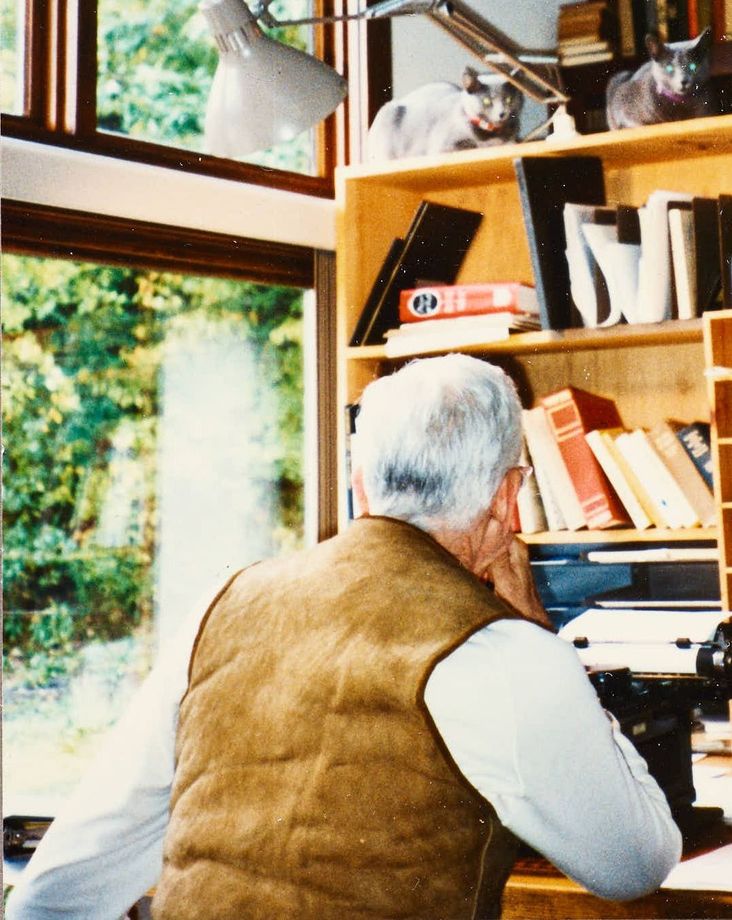 J.D. Salinger at his writing desk in Cornish, N.H. in 1993. His cats look on as he types.`