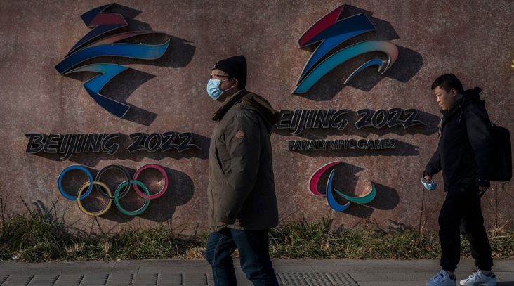 Visitors walk by the logos for the Beijing 2022 Winter Olympics and Paralympics, Dec. 7, 2021 in Beijing, China. The games are set to open on Feb. 4, 2022. (Kevin Frayer/Getty Images)