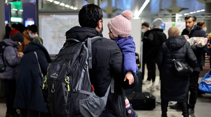 A man carries a child after refugees from the Ukraine arrive at the main train station in Berlin, March 1, 2022. in Berlin, Germany. (Hannibal Hanschke/Getty Images)