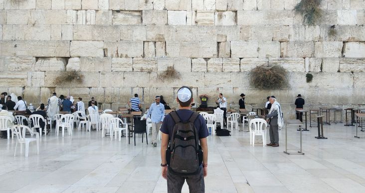Back of a young tourist in casual clothes near the Western Wall in Jerusalem (2018).