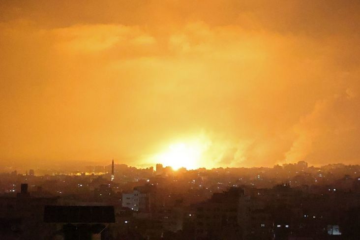 An explosion lights the sky following an Israeli air strike on Beit Lahia in the northern Gaza Strip on May 14, 2021.