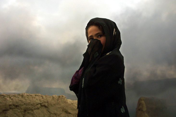 An Afghan girl stands late 01 November 2001 close to a brick factory in the village of Dasht-i-Qala , some 10 kilometers from the front line with Taliban forces, in the Takhar province. The US-led air campaign in Afghanistan entered a 26th day with Washington warning the Taliban regime to brace for more carpet-bombing of their positions across the country.