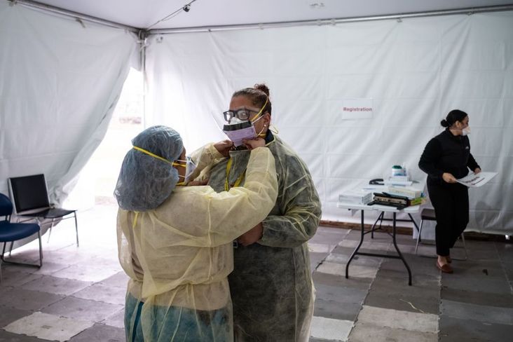 Nurses adjust protective masks inside a testing tent at St. Barnabas hospital on March 20, 2020 in New York City.