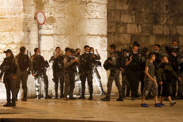 Israeli border guards stand at attention during the funeral of Iyad Hallak, a disabled Palestinian man who was shot dead by Israeli police after they mistakenly thought he was armed with a pistol, in Jerusalem late on May 31, 2020.