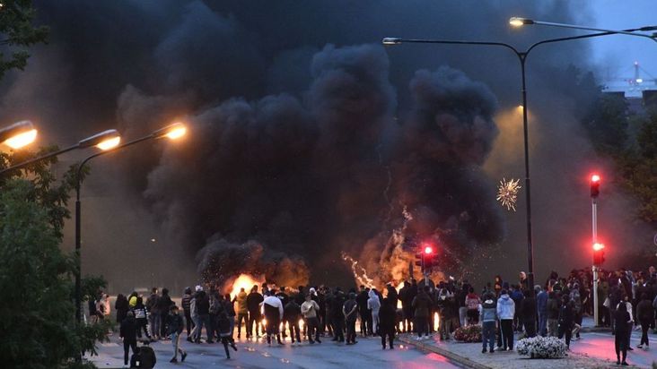 Smoke billows from burning tyres, pallets and fireworks as a few hundred protesters riot in the Rosengard neighbourhood of Malmo, Sweden, on August 28, 2020.