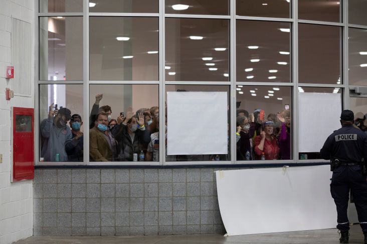 A crowd chants "stop the count," and pounds on the glass windows and doors to the entrance of the Central Counting Board in the TCF Center after partisan election challengers were told that the capacity for election challengers has been met on November 4, 2020