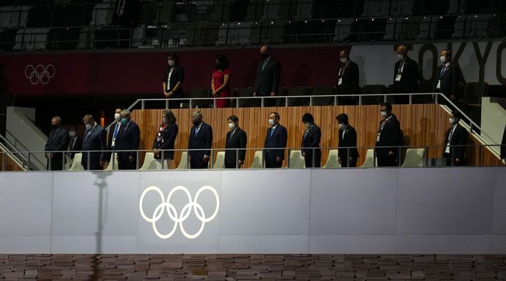 The emperor of Japan, International Olympic Committee president Thomas Bach and others stand for a moment of silence during the opening ceremony of the Tokyo 2020 Olympic Games. (Martin Rickett/PA Images via Getty Images)