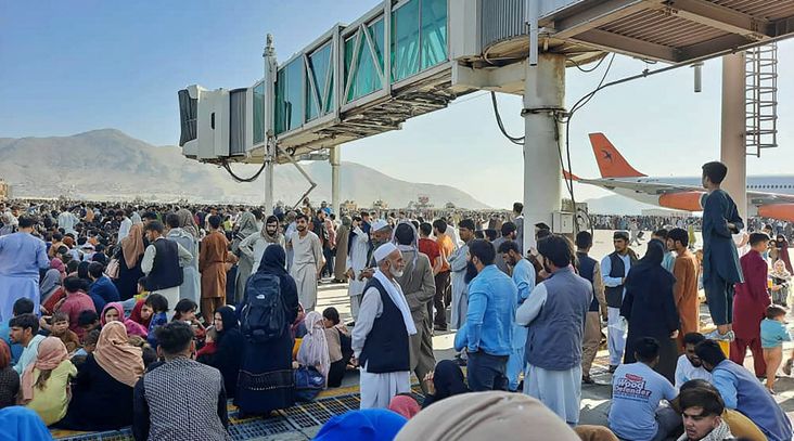 Afghans crowd at the tarmac of the Kabul airport on Aug. 16, 2021, in an effort to flee the country as the Taliban retook control after 20 years.