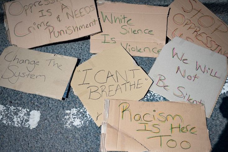 Signs from a protest litter the ground.