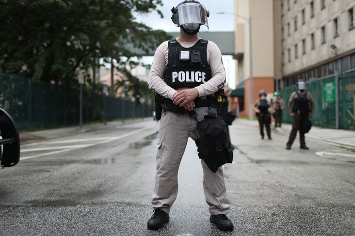 Miami-Dade police officers watch as demonstrators walk past during a protest against police brutality and the recent death of George Floyd on June 02, 2020 in Miami, Florida.