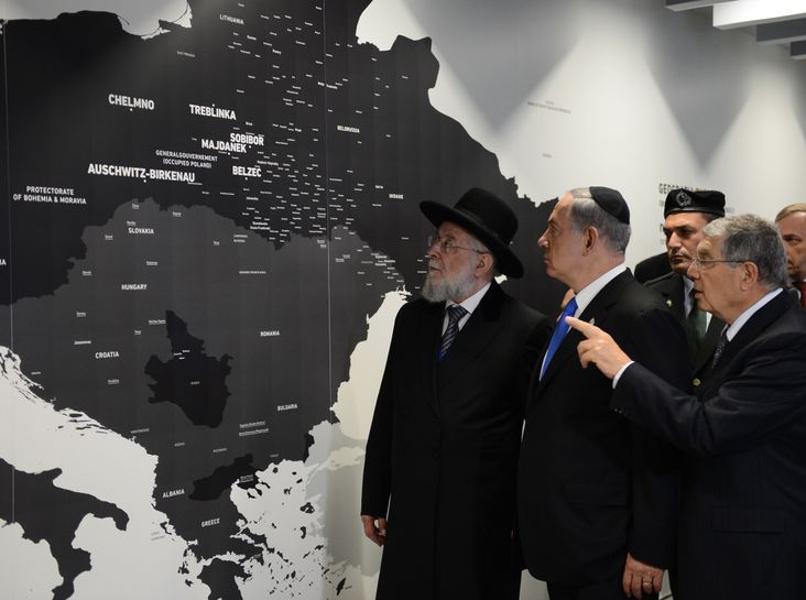 Yad Vashem Chairman Avner Shalev, Israeli Prime Minister Benjamin Netanyahu and Rabbi Yisrael Meir Lau point at a map showing where Jews were killed during the Holocaust at the opening of the Permanent Exhibition SHOAH at former Nazi death camp in the Auschwitz-Birkenau State Museum.