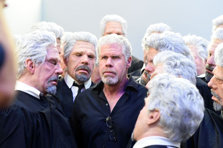 Ron Perlman, surrounded by people dressed like Ron Perlman