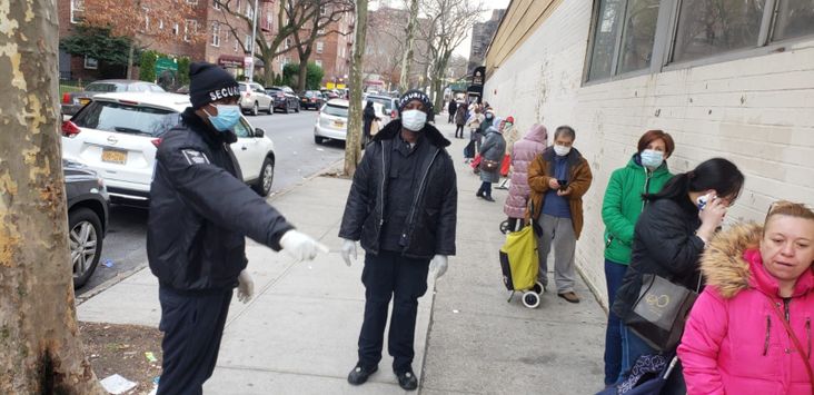 Masbia employees help clients maintain a safe distance as they wait to pick up groceries.
