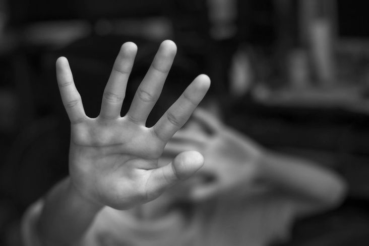 Black and white hands shield someone from the camera.