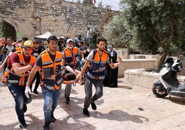 Palestinian medics evacuate a wounded protester from the Aqsa mosque compound in Jerusalem's Old City amidst clashes with Israeli security forces.