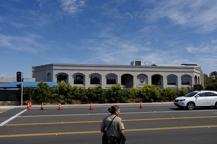 A San Diego County Sheriff's deputy directs traffic in front of the Chabad of Poway synagogue on Sunday, April 28, 2019 in Poway, California.