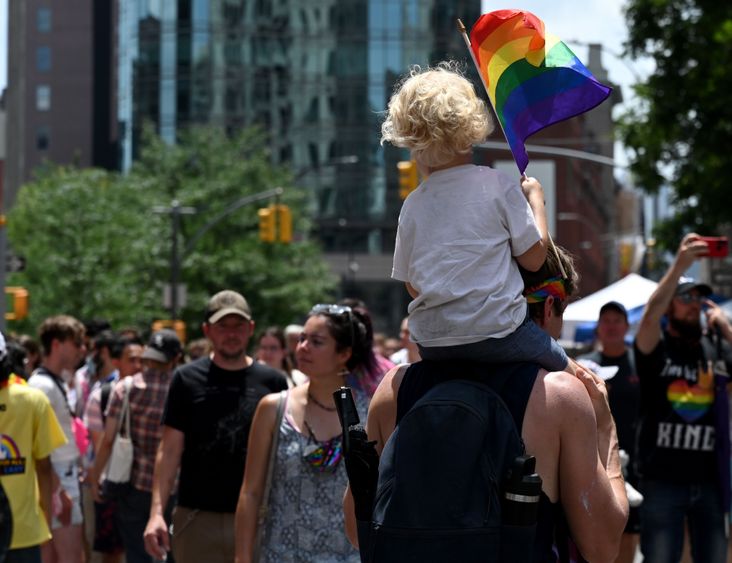 Child waves Pride flag