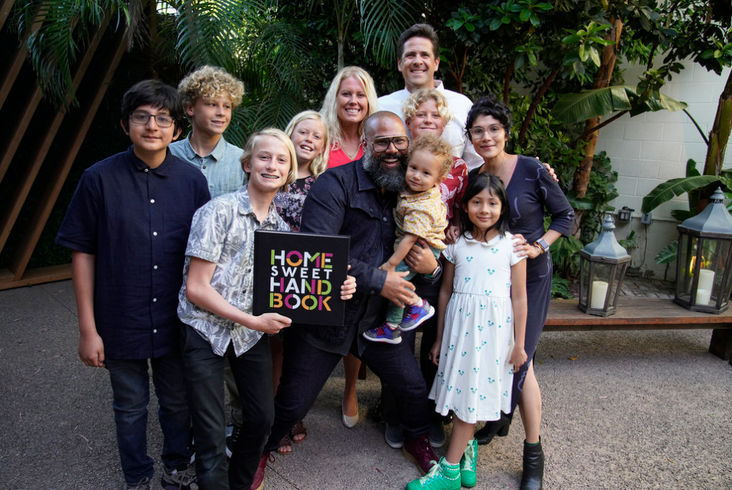 The two families on "Home Sweet Home" pose together.
