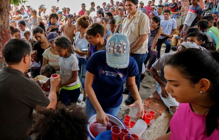 Venezuelan migrants receive food outside a migrant shelter in Cucuta, Colombia, on the border with Venezuela, May 1, 2019.