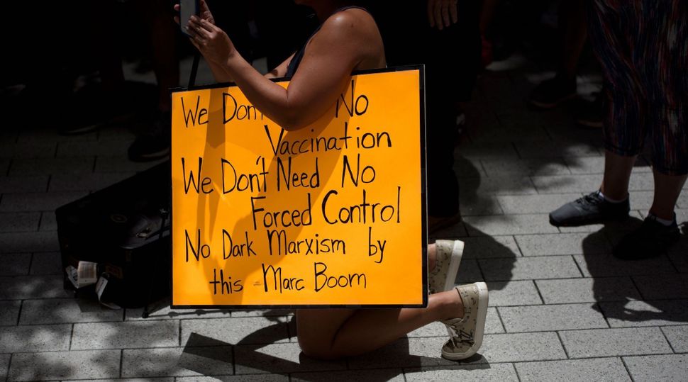 Anti-vaccine rally protesters hold signs outside of Houston Methodist Hospital in Houston, Texas, on June 26, 2021. (Mark Felix/AFP via Getty Images)